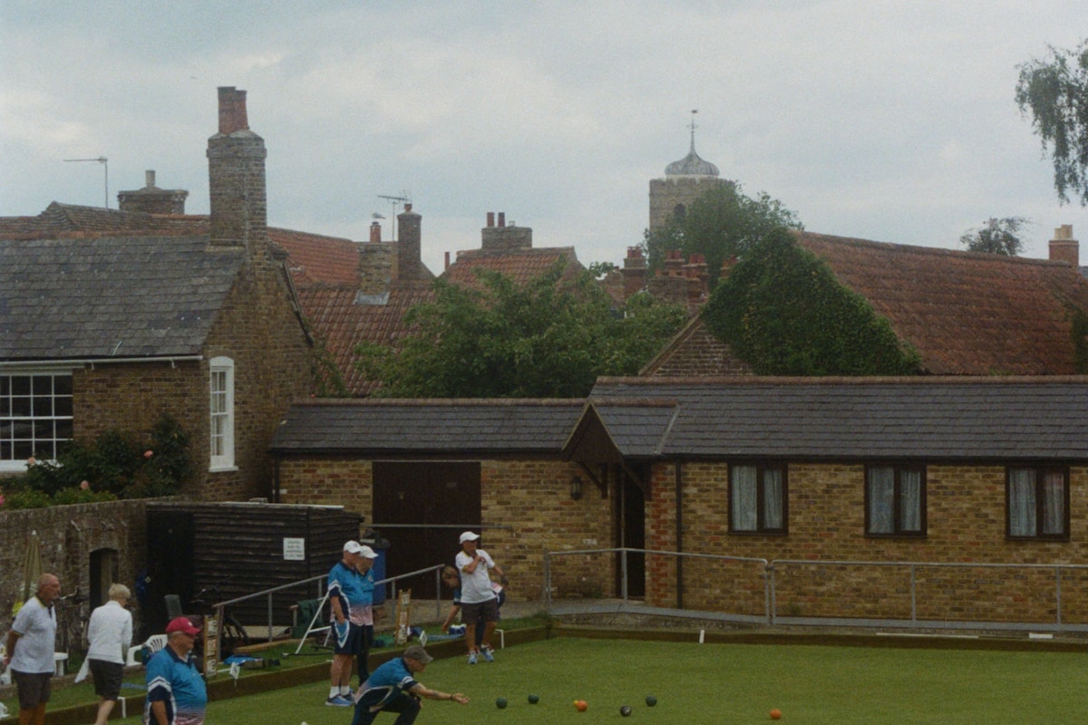 People playing lawn bowls on a sunny green field